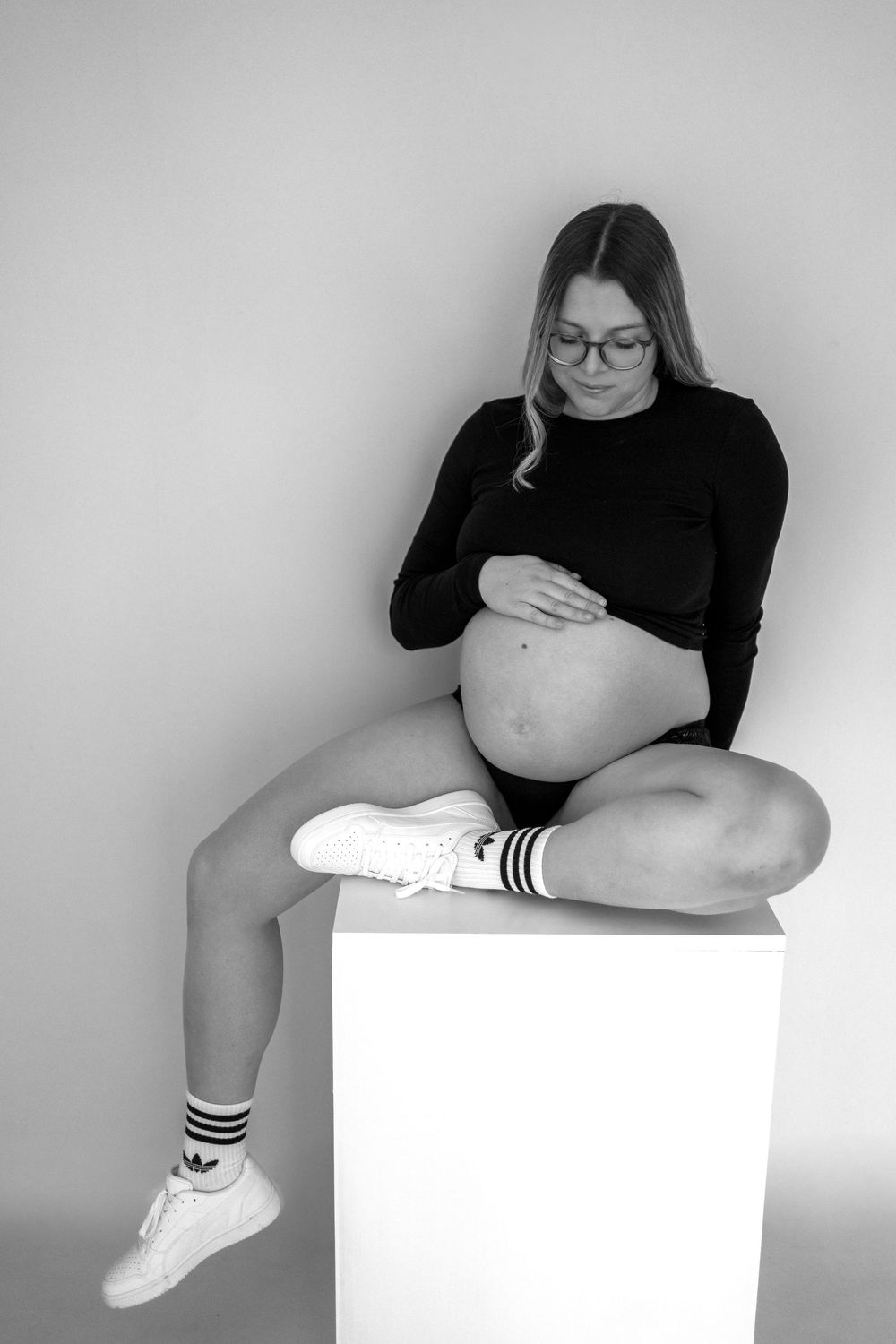 A series of minimalist black and white photos showing legs in white socks and sneakers resting on white surfaces.