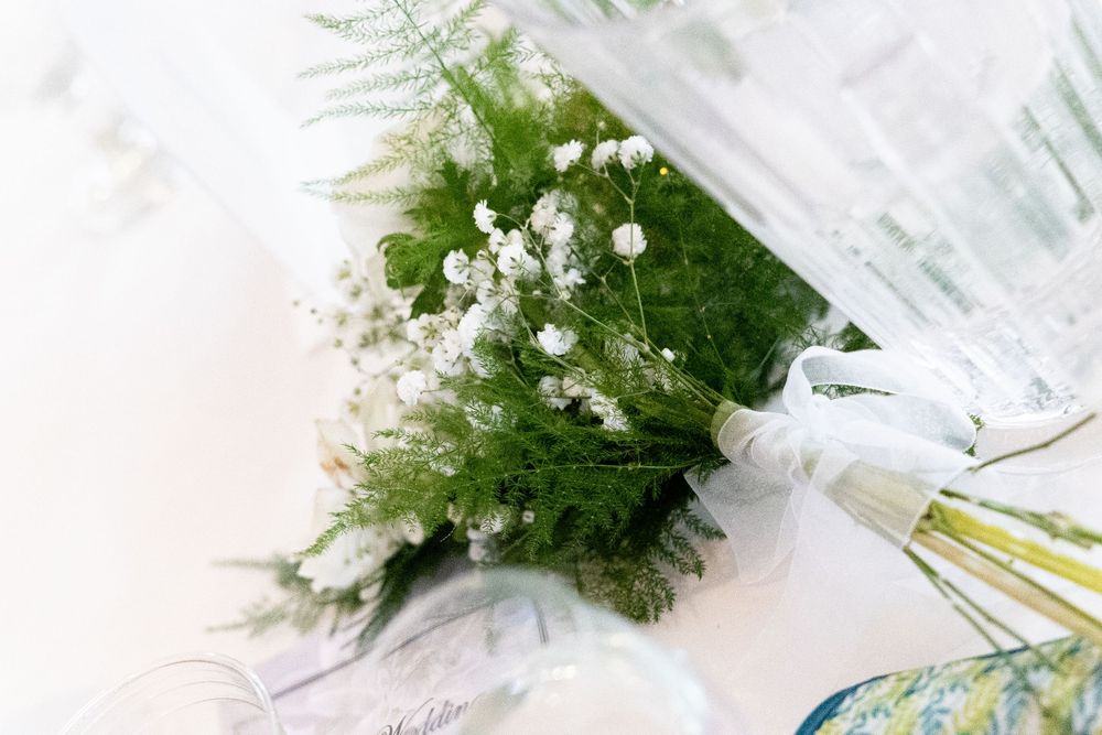 White flowers and greenery arranged in elegant glass vases create a romantic wedding centerpiece display.