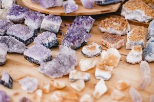 Raw amethyst crystal clusters scattered on a wooden surface.
