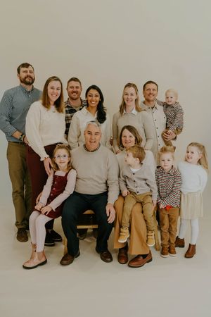 Extended family gathering for a professional portrait session in coordinated neutral outfits.