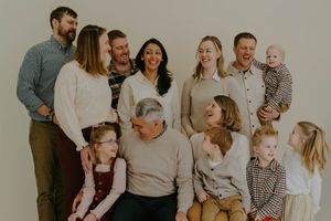 Multi-generational family portrait with everyone wearing coordinated casual attire.