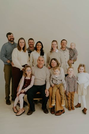 Large family group posed together in neutral tones for a professional studio photograph.