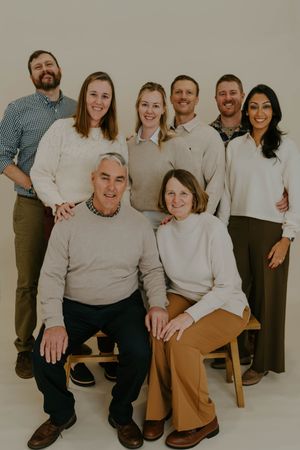 Family members arranged in casual poses for a professional studio photography session.