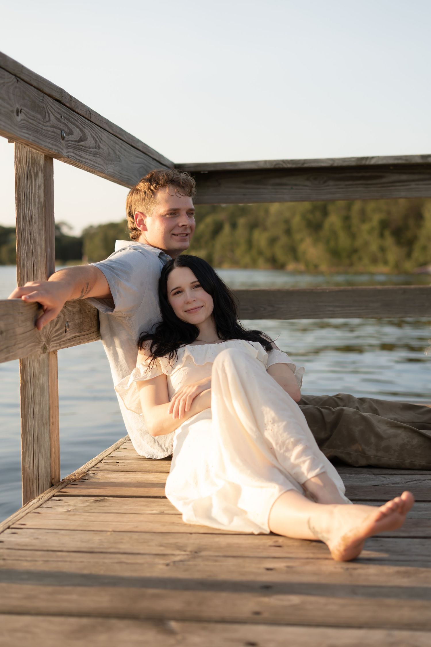 Family photos of a couple lakeside on the dock at golden hour in the midwest.