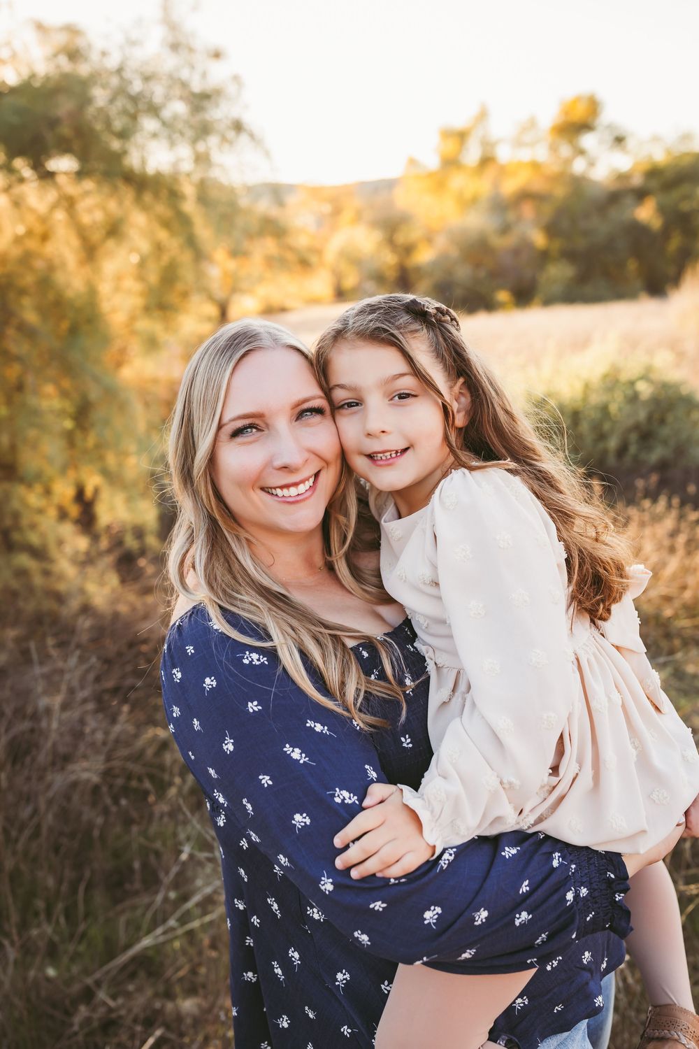 Mother and daughter sharing tender moments together in warm evening sunlight.