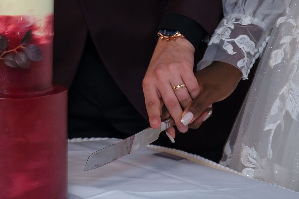 A person's hands sign a marriage license or official document with a pen during a wedding ceremony.
