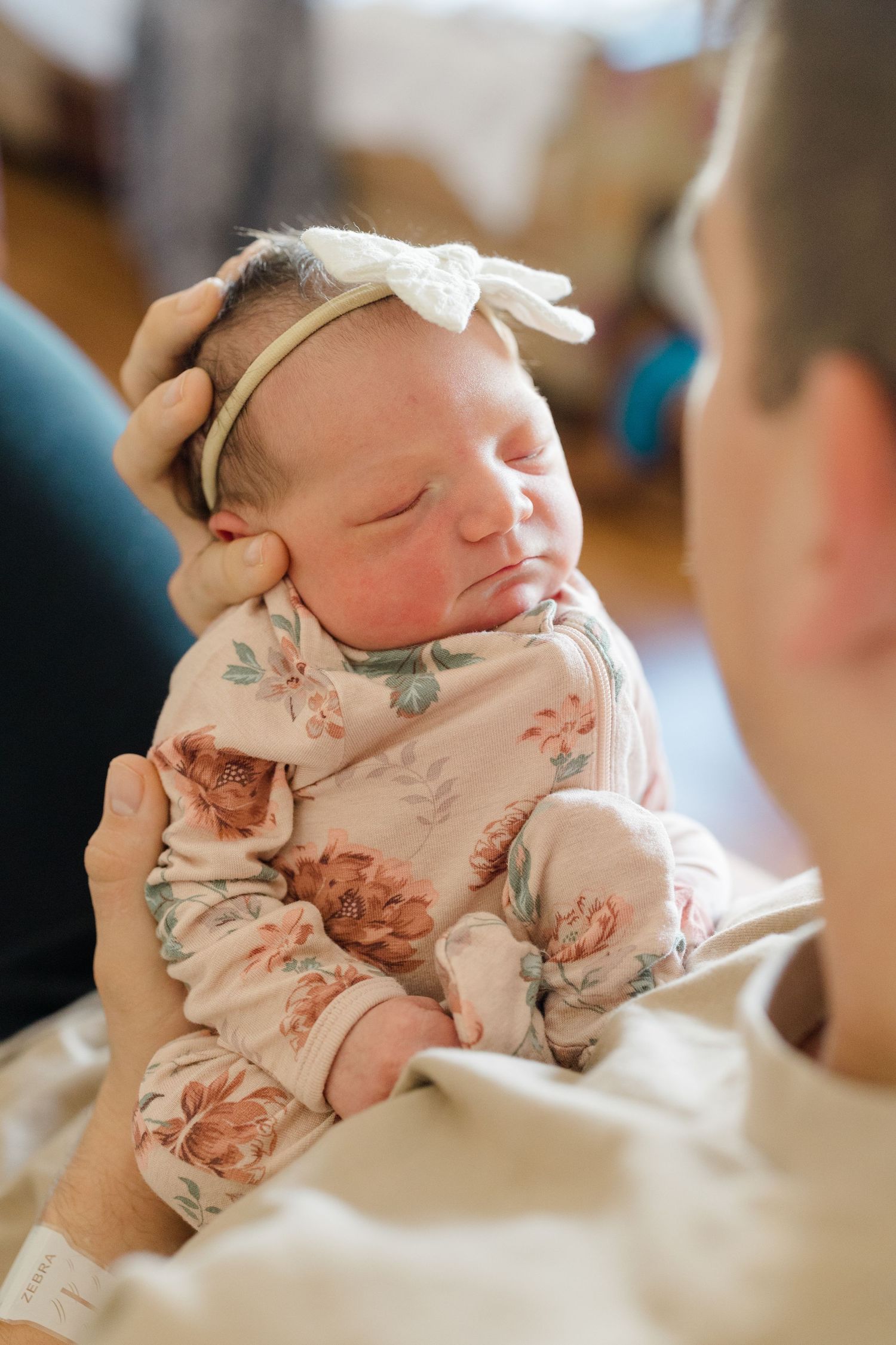 A tender family moment captured in a series of photos showing parents bonding with their newborn baby on a white bed.