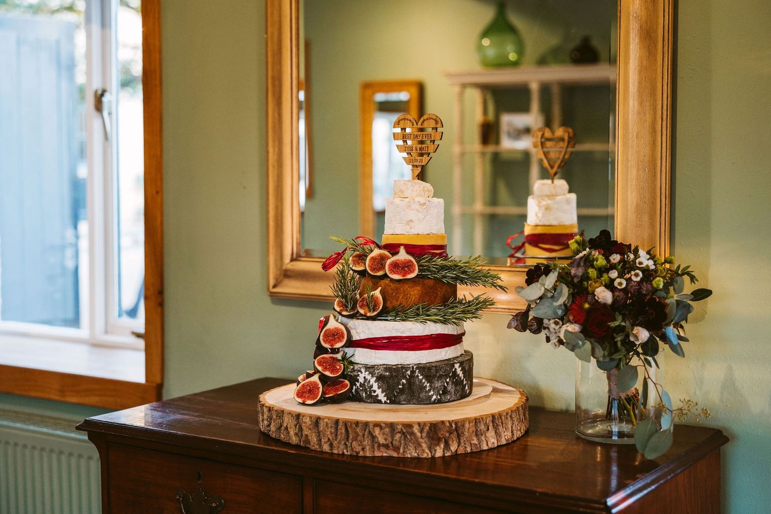 Rustic wooden table decorated with Christmas ornaments, candles and natural greenery in a cozy interior setting.