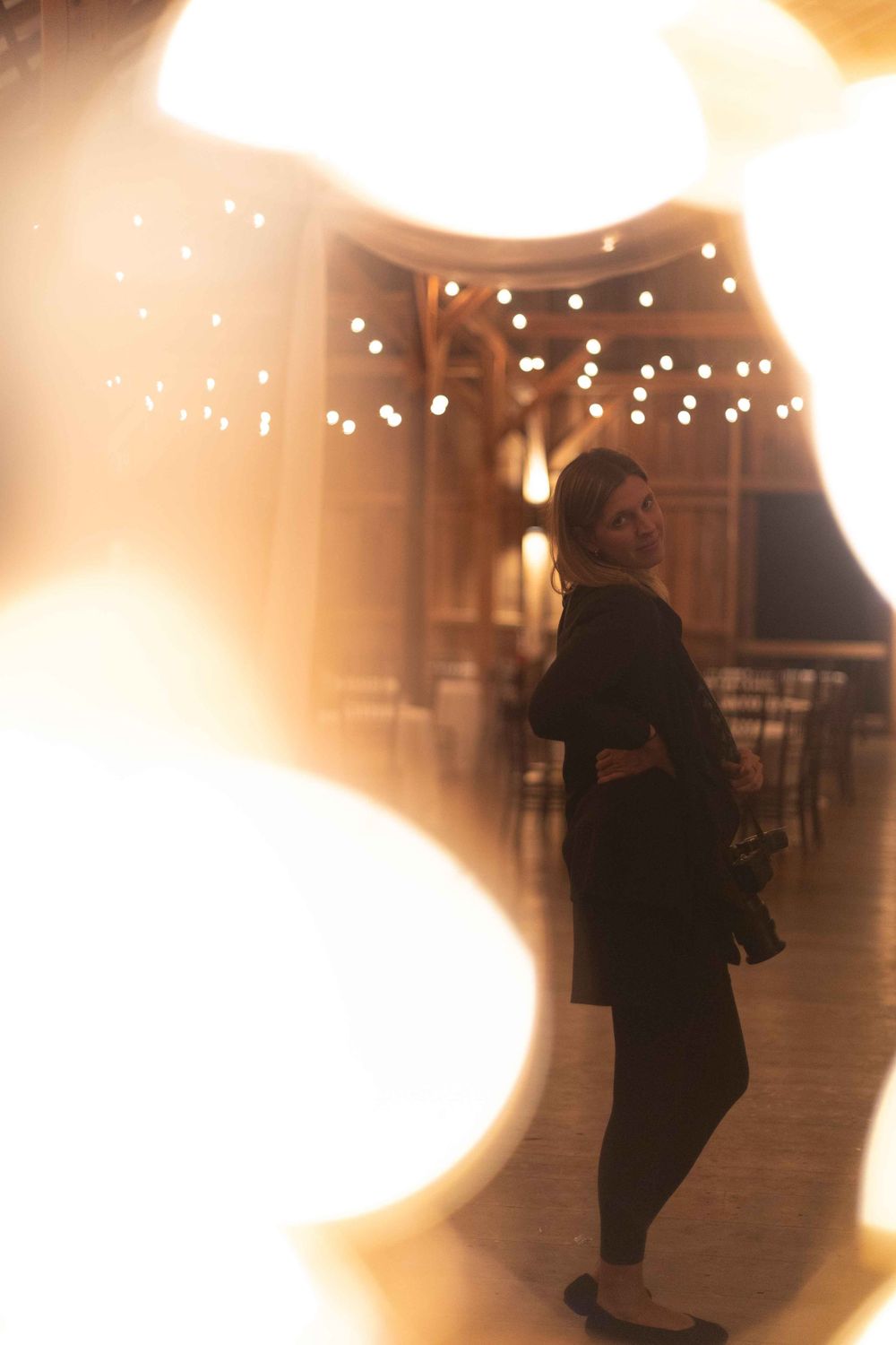 A silhouetted figure stands in a dimly lit room with string lights overhead creating a dreamy, romantic atmosphere.