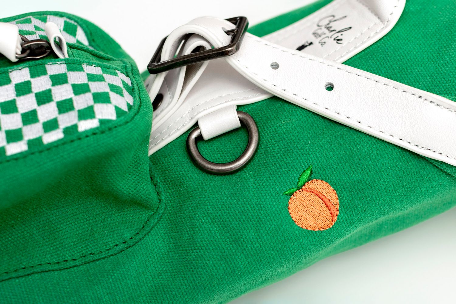 Close-up view of green fabric with white checkerboard pattern and orange circular details.