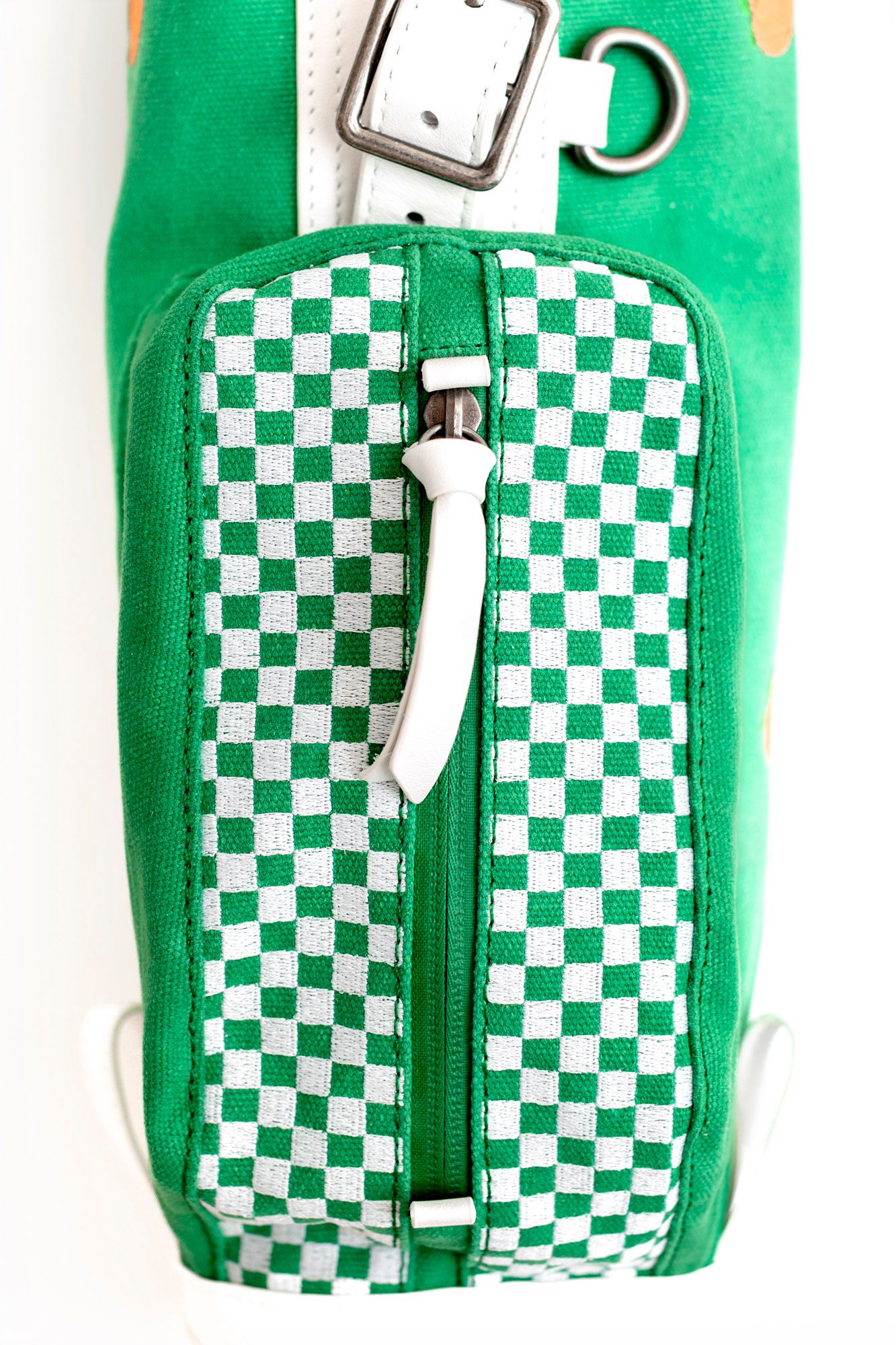 Green and white checkered patterned toiletry bags with white zippers and handles displayed in a row.