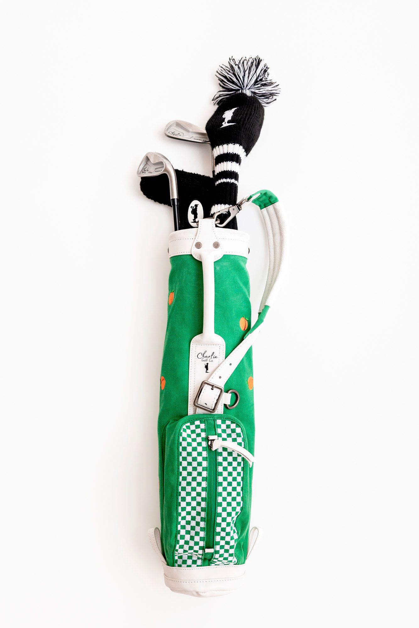 Four white and green golf club head covers featuring playful cartoon bunny designs and checkered patterns.
