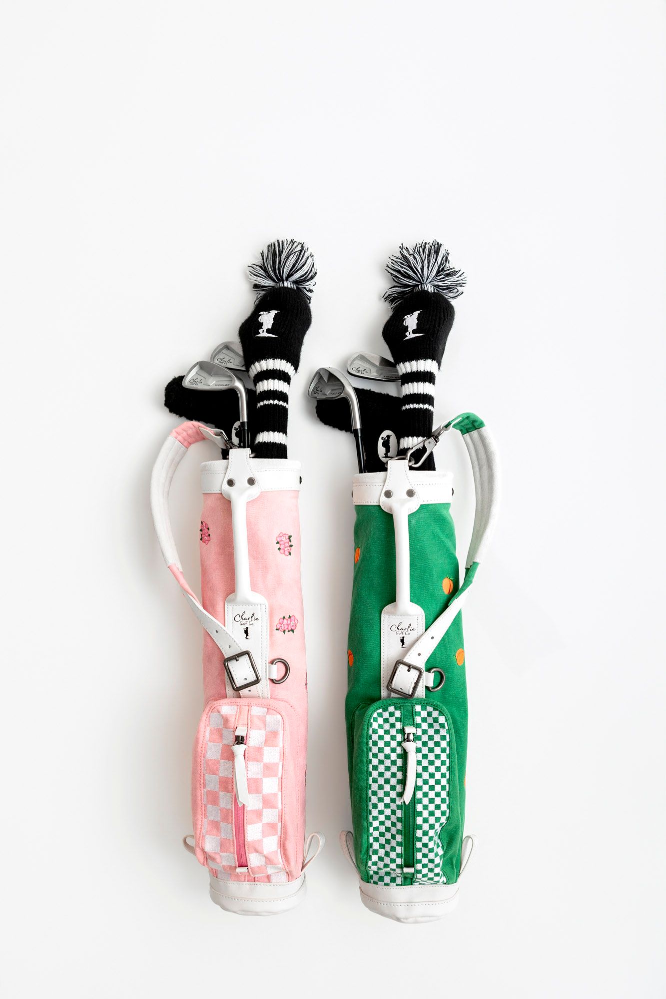 Vintage-style pink and green golf club bags with checkered patterns displayed against a white background.
