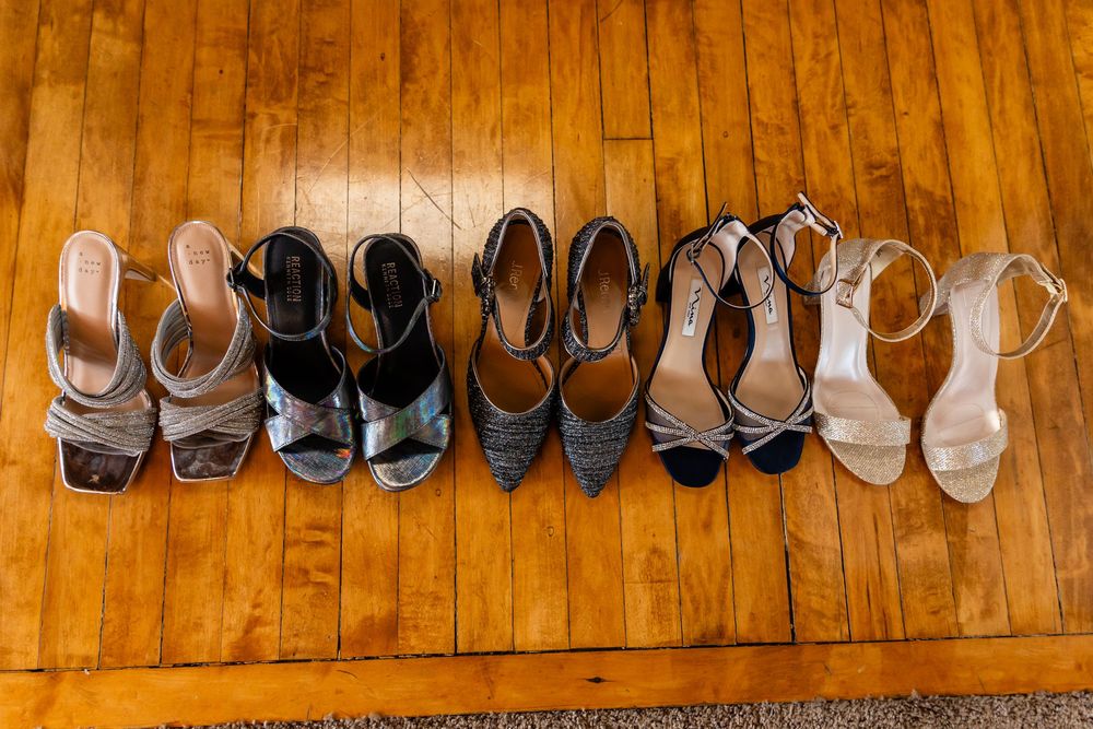 Five pairs of elegant heeled sandals arranged in a row on a hardwood floor.