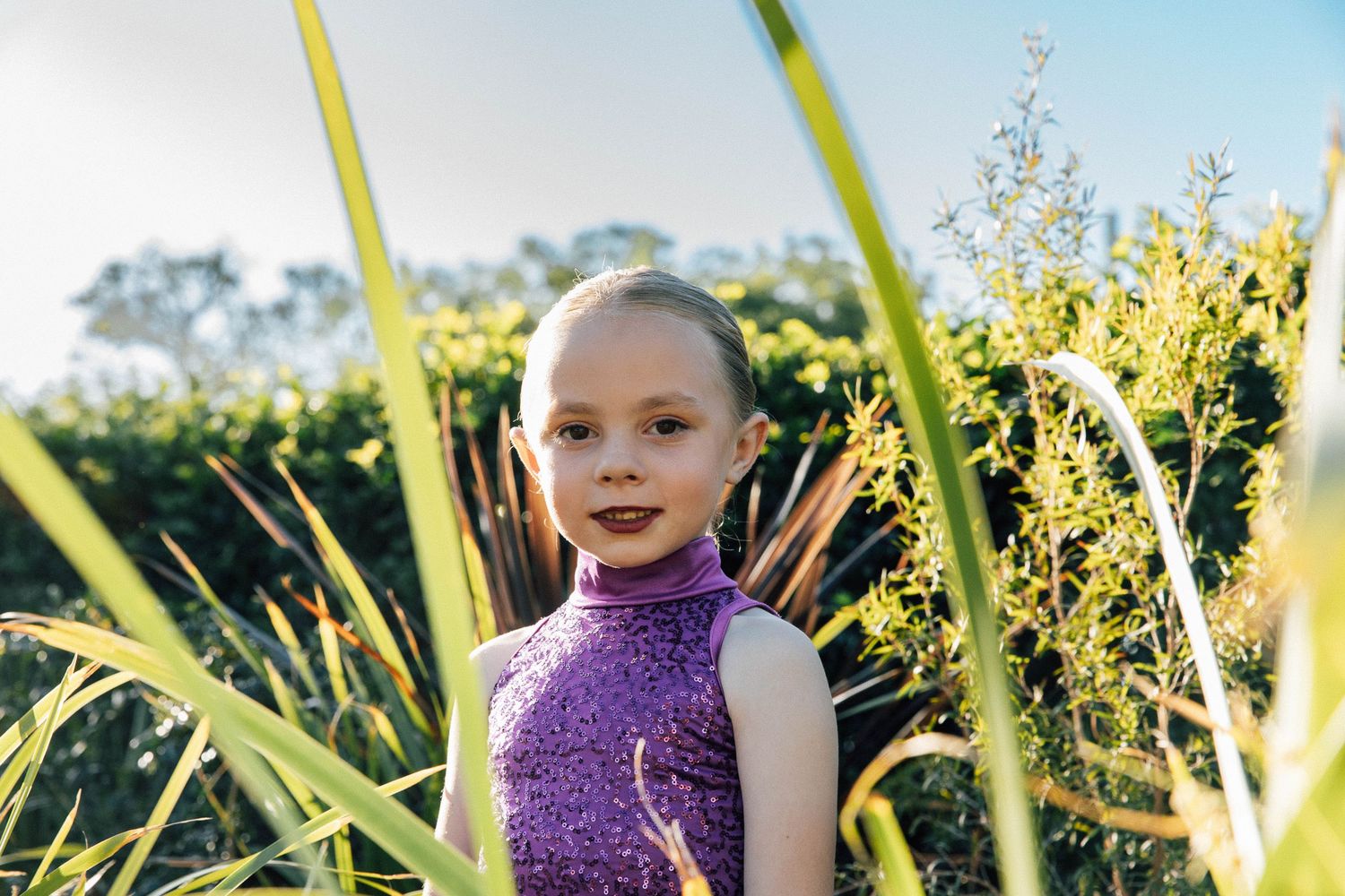 Little girl looking through the plants during a dance costume photo shoot.