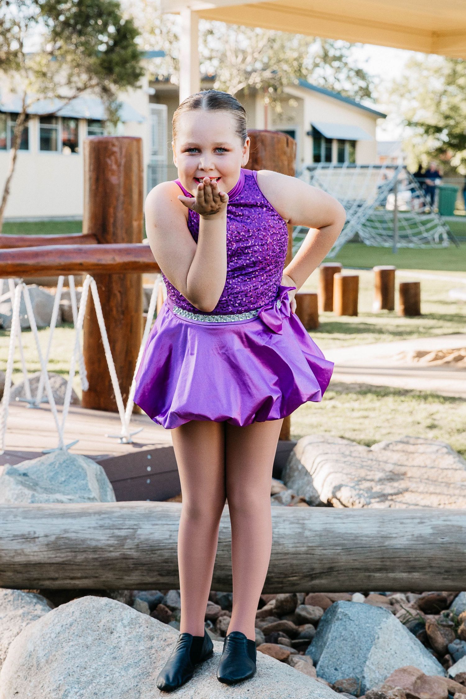 Little girl standing on a rock in a creek during a dance costume photo shoot.