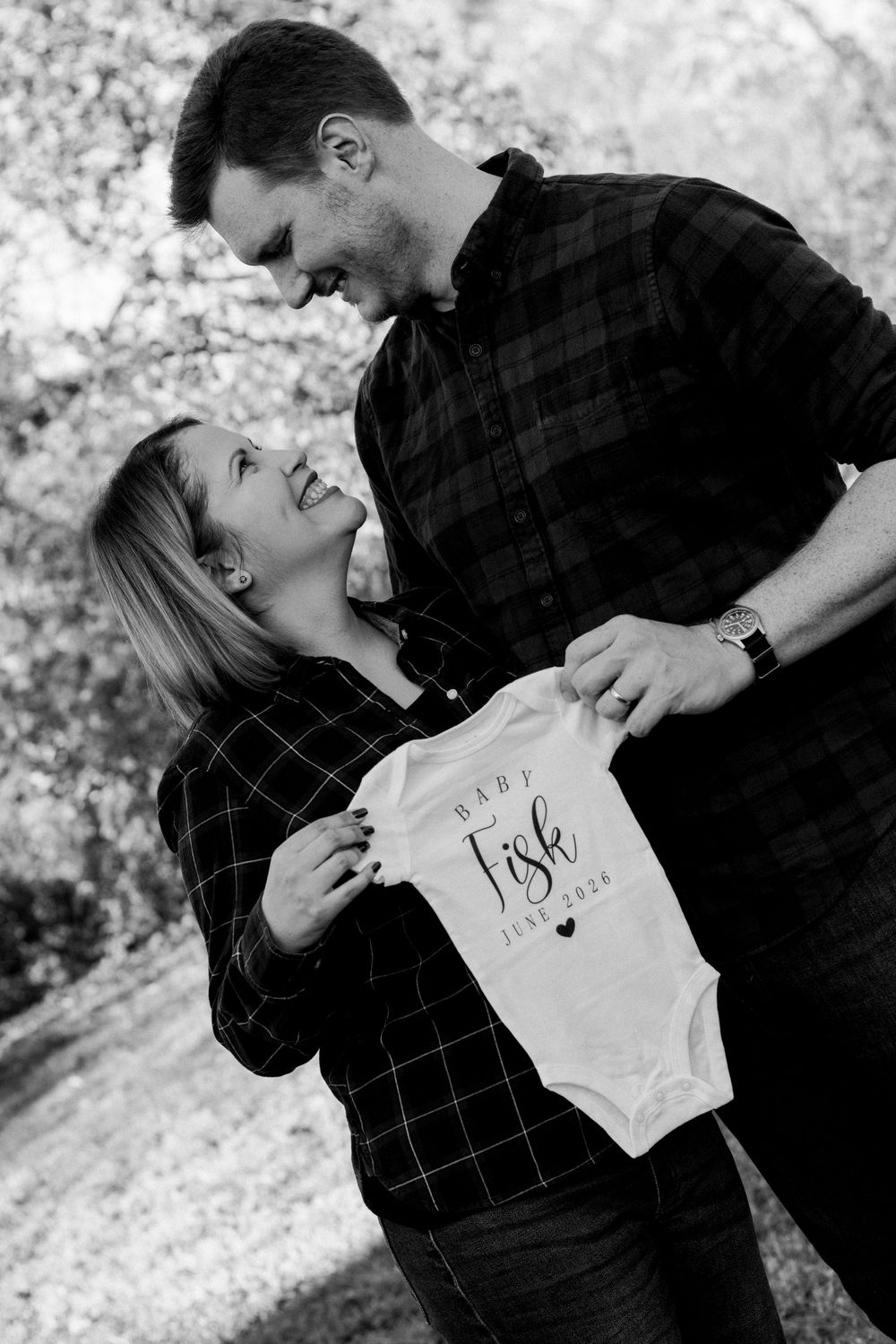 couple holding up onesie
