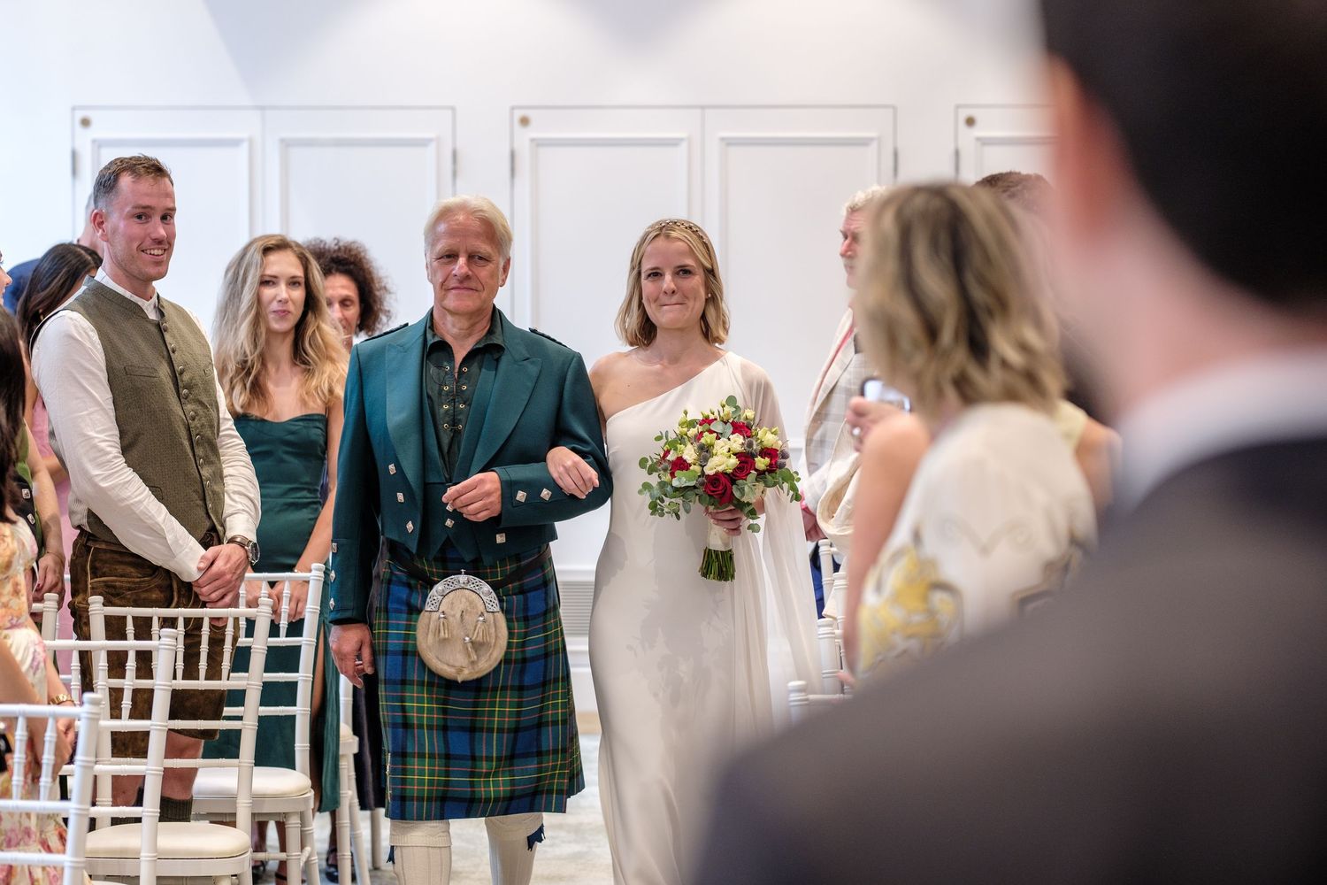 A bride and groom standing together and smiling on their wedding day.