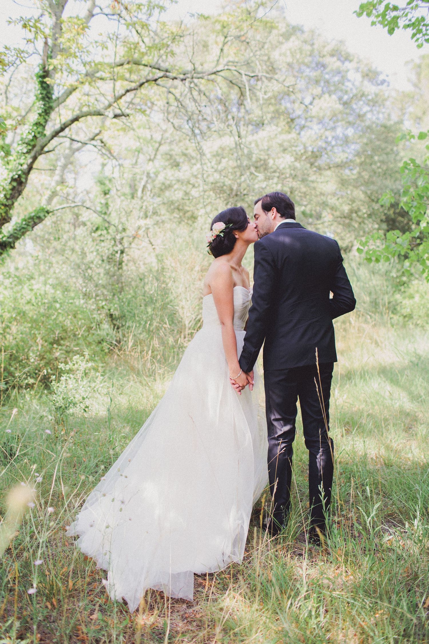 Wedding couple walking through nature at a château in France with soft light and romantic destination atmosphere