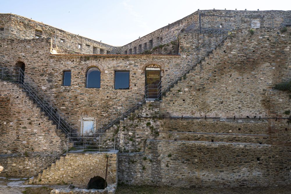 Ancient stone fortress ruins with weathered walls and arched windows showing architectural details of a historic structure.