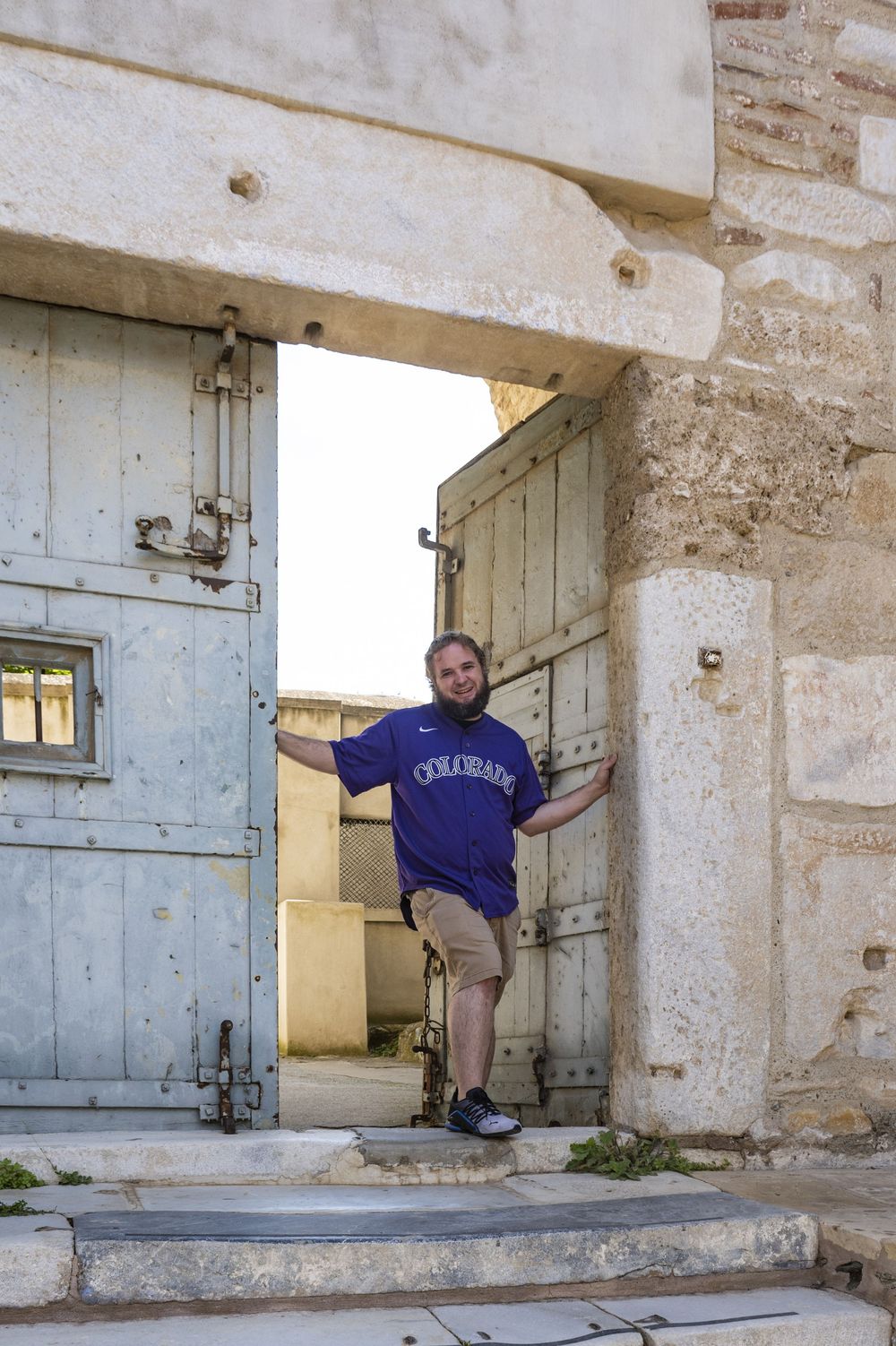 Four sequential images showing a person climbing through an old stone doorway in a historic building.