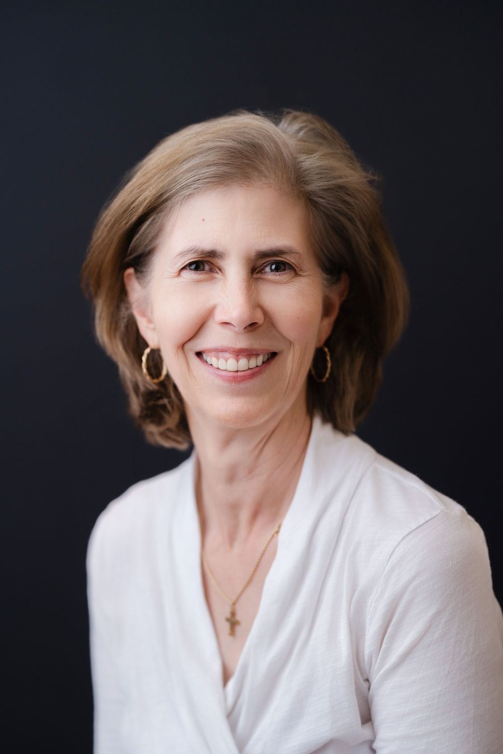 Professional headshot series showing a woman in a white blazer against dark background with warm, engaging expressions.