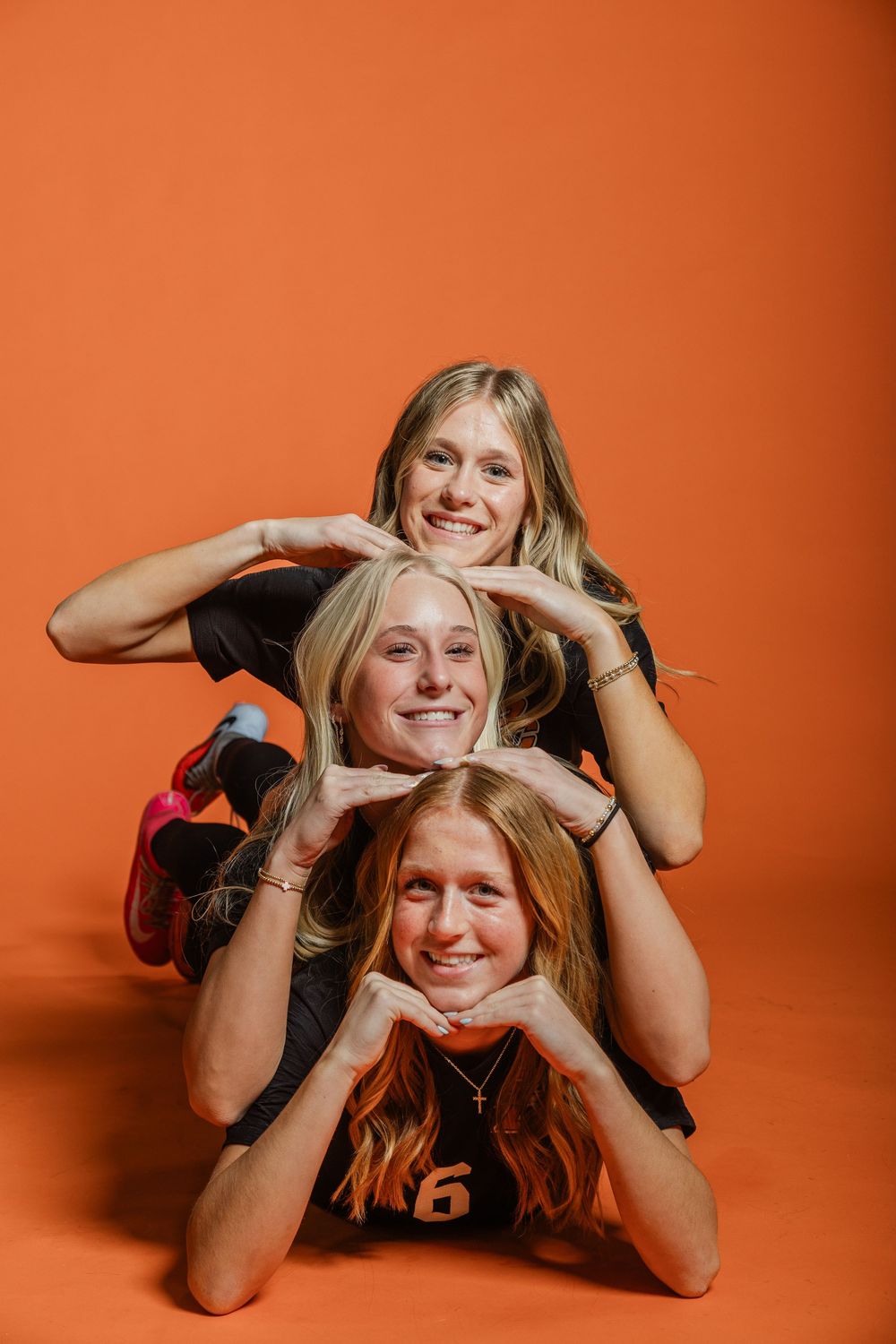 Series of casual poses on orange backdrop showing relaxed and joyful expressions.
