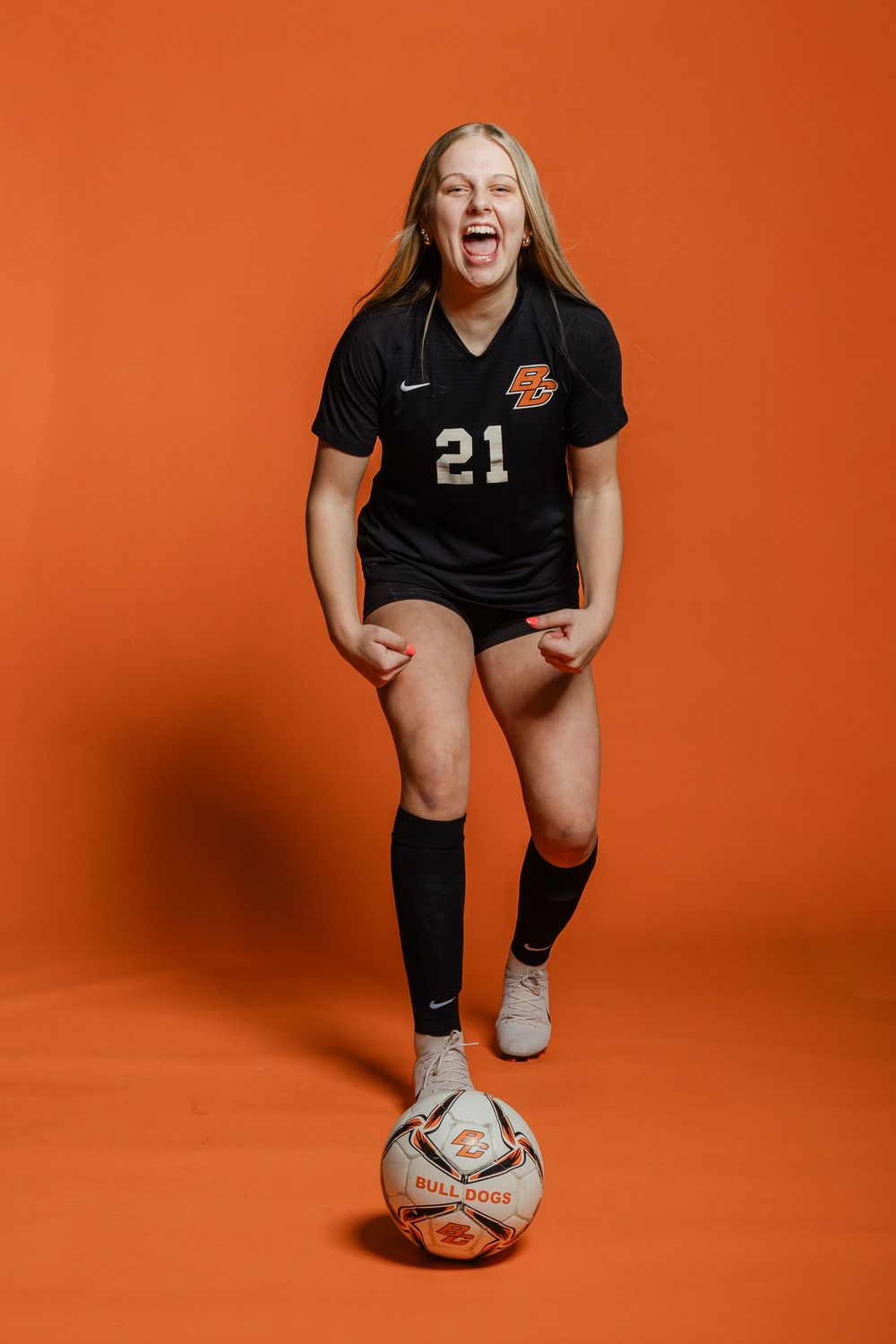 Four sequential action shots of a volleyball player in black uniform posing with a ball against an orange backdrop.
