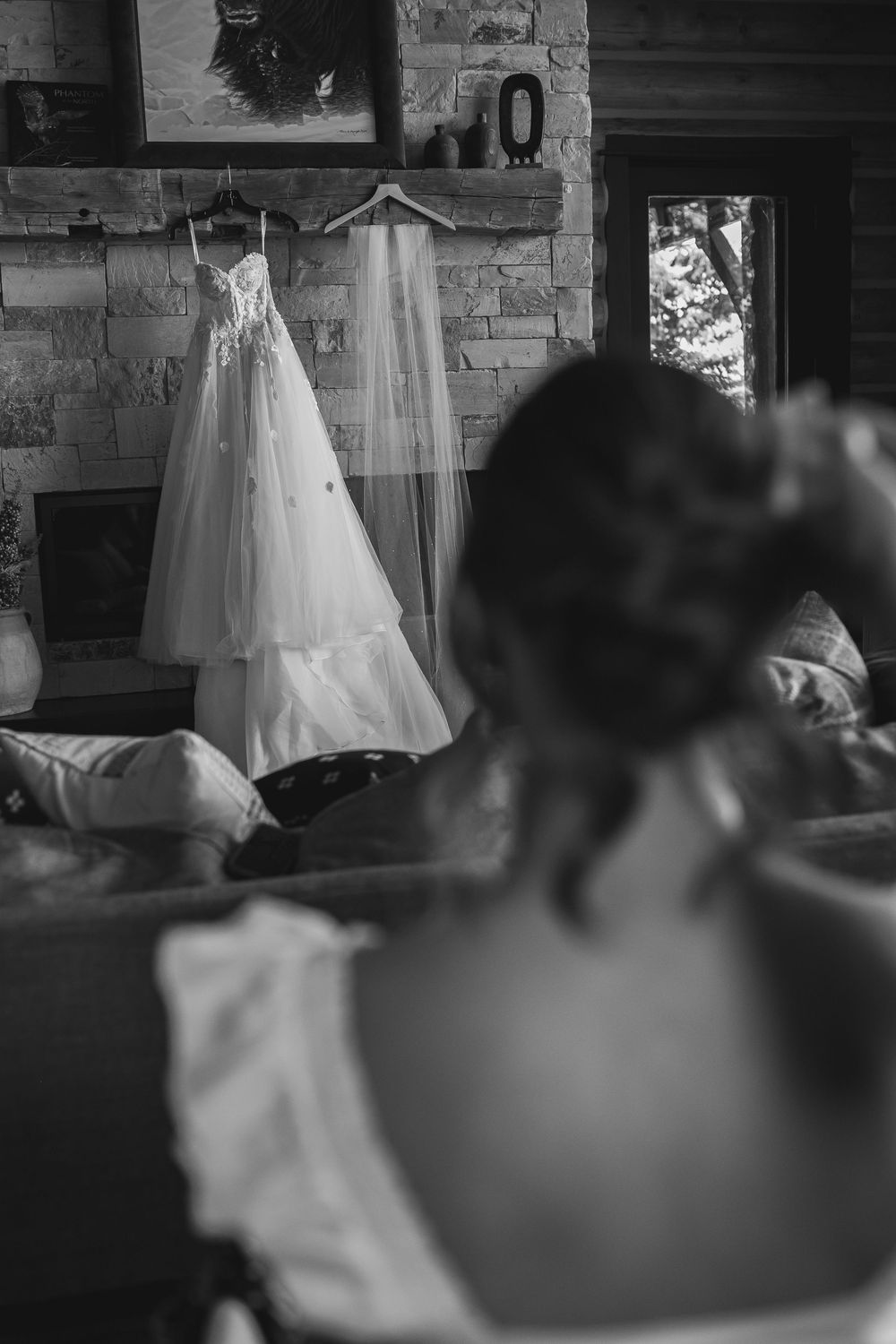 A sequence of black and white photos showing wedding dresses hanging in a rustic log cabin setting.