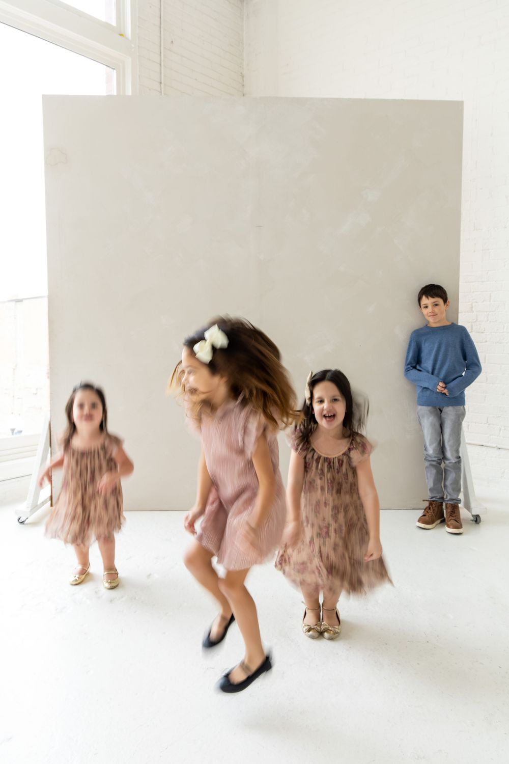 Three artistic photos show dancers in pink dresses performing dynamic movements in a minimalist white studio space.