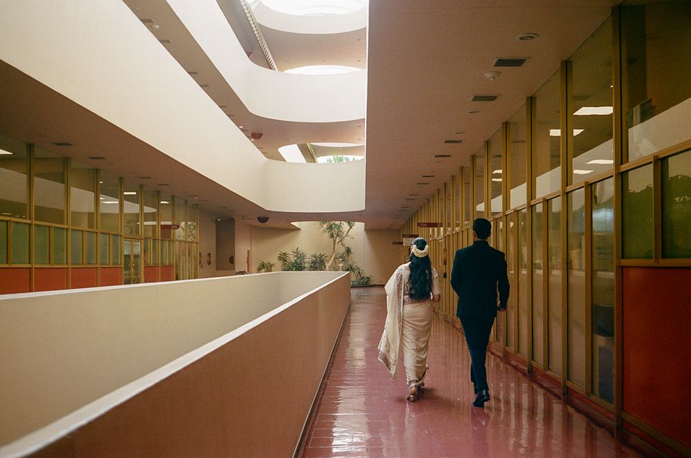Long institutional hallway with fluorescent lighting and orange walls showing multiple similar views of the corridor.