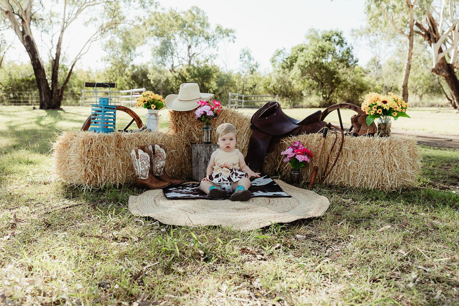 Girl sitting on cowhide mat at cowgirl cake smash professional photo shoot