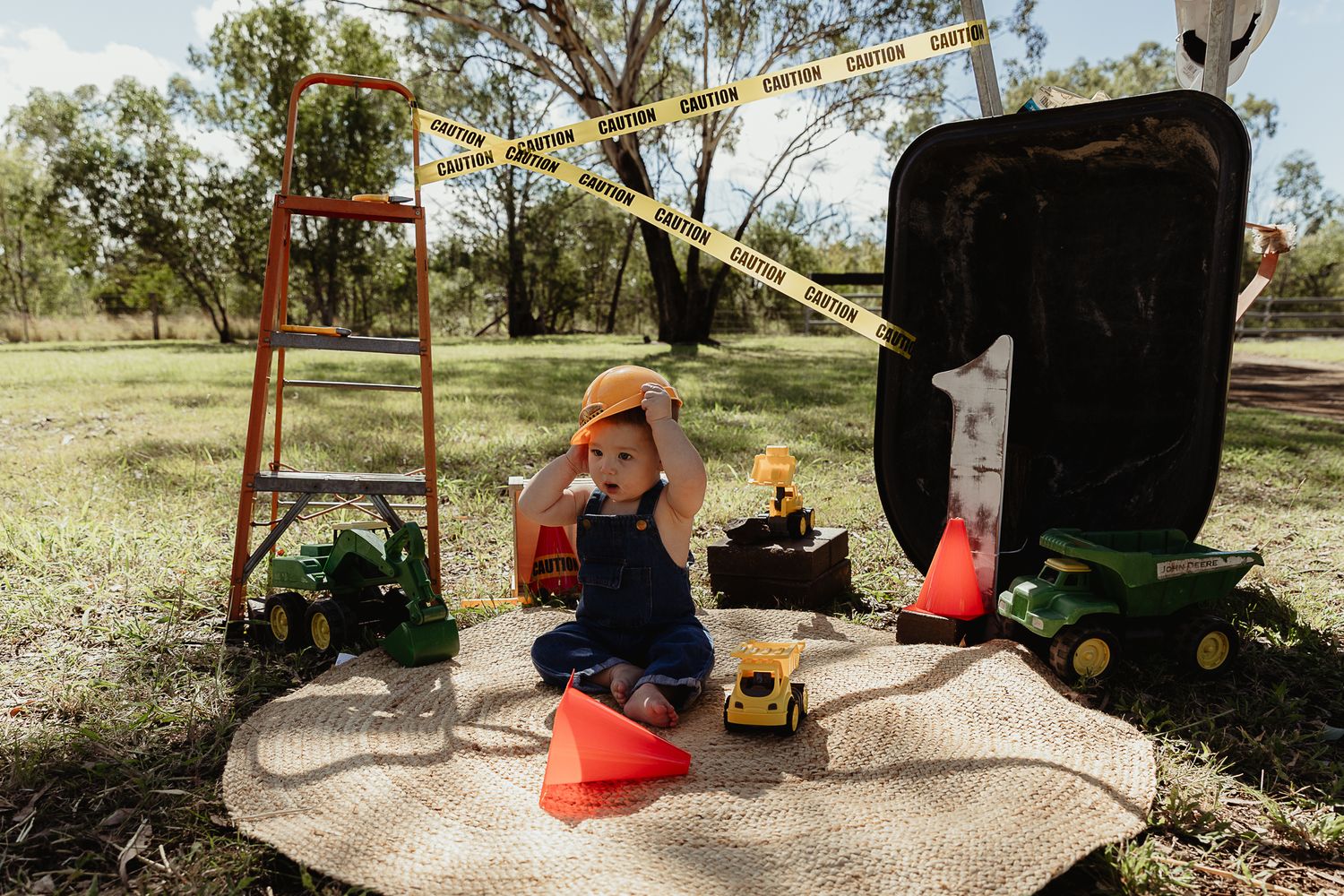 Boy playing with a hard hat at a construction cake smash photo shoot