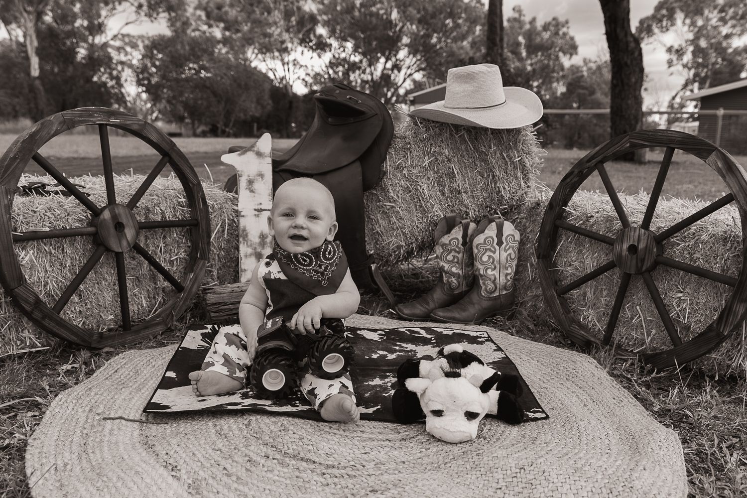 Baby Boy sitting on a cowhide mat at a cowboy cake smash photo shoot