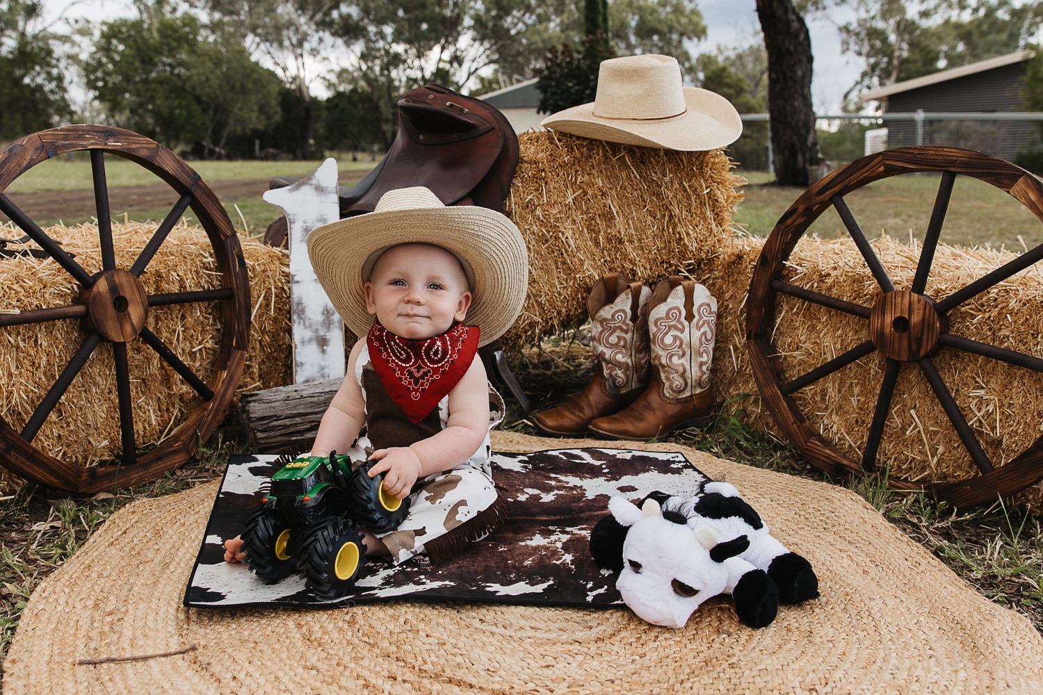 Baby Boy sitting on a cowhide mat at a cowboy cake smash photo shoot