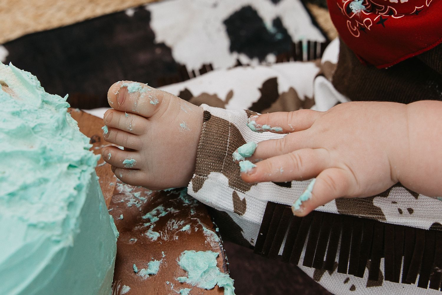 Baby Boy with foot in cake at a cowboy cake smash photo shoot