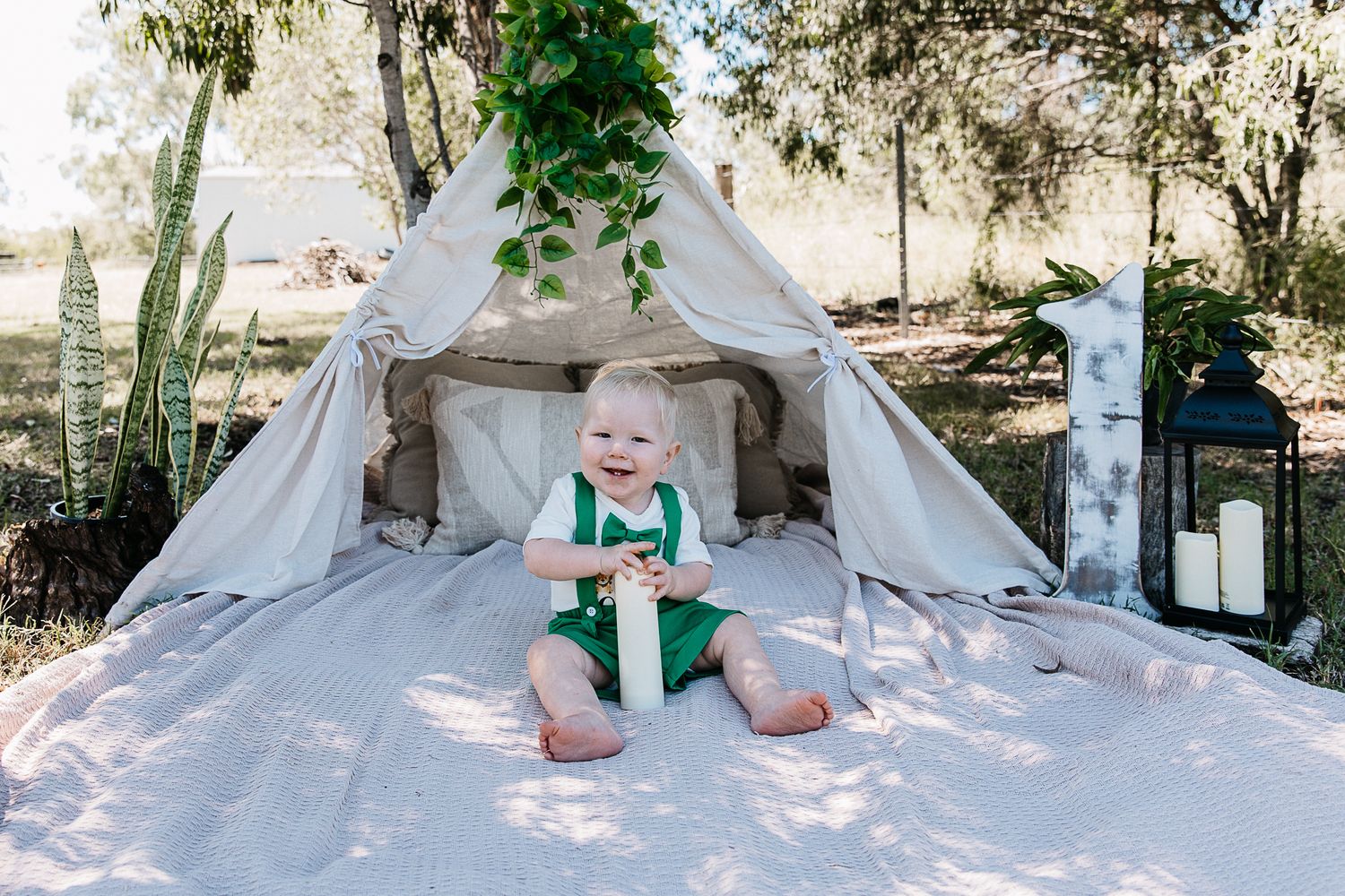 Baby boy sitting on a rug with cake at a "Wild One" professional cake smash photo shoot