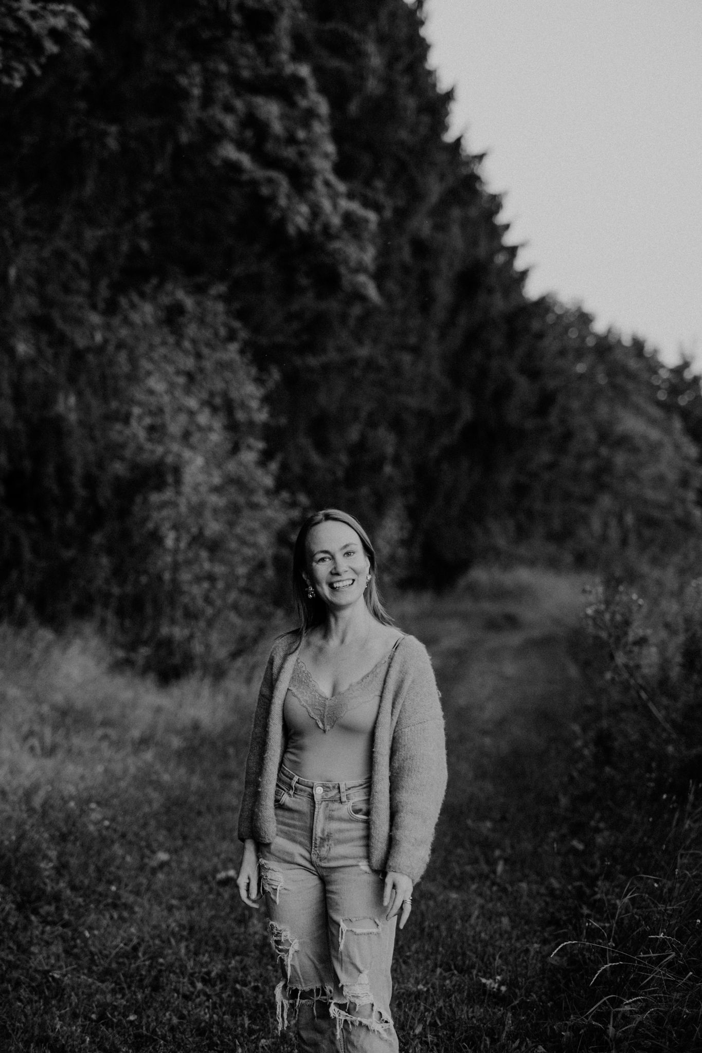 A black and white photo series showing a person in various candid poses against a natural outdoor background.