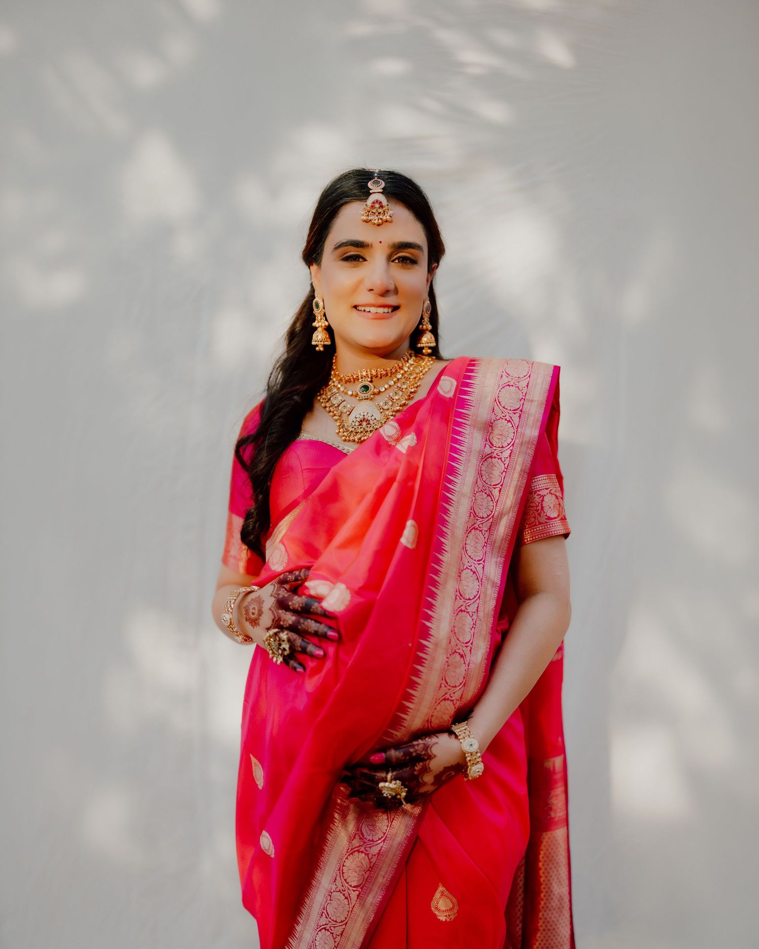 Maternity photoshoot in Dubai – South Asian woman in traditional pink sari, studio portrait