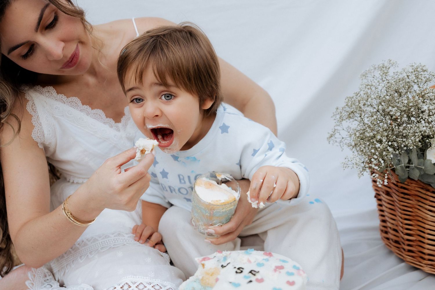 Lifestyle maternity photoshoot in Dubai with mother feeding toddler in soft natural light