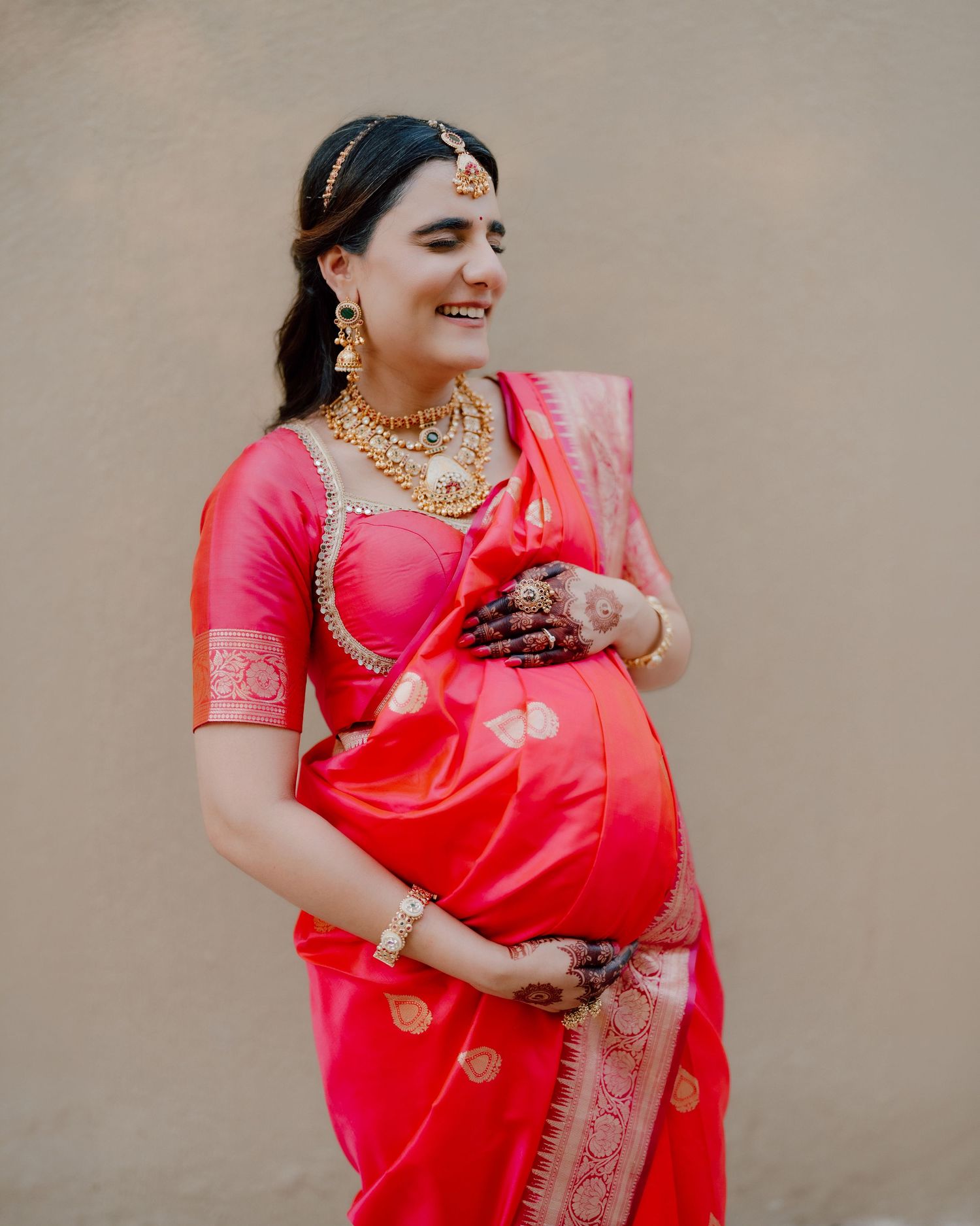 Maternity photoshoot in Dubai – South Asian pregnant woman in pink sari, belly close-up
