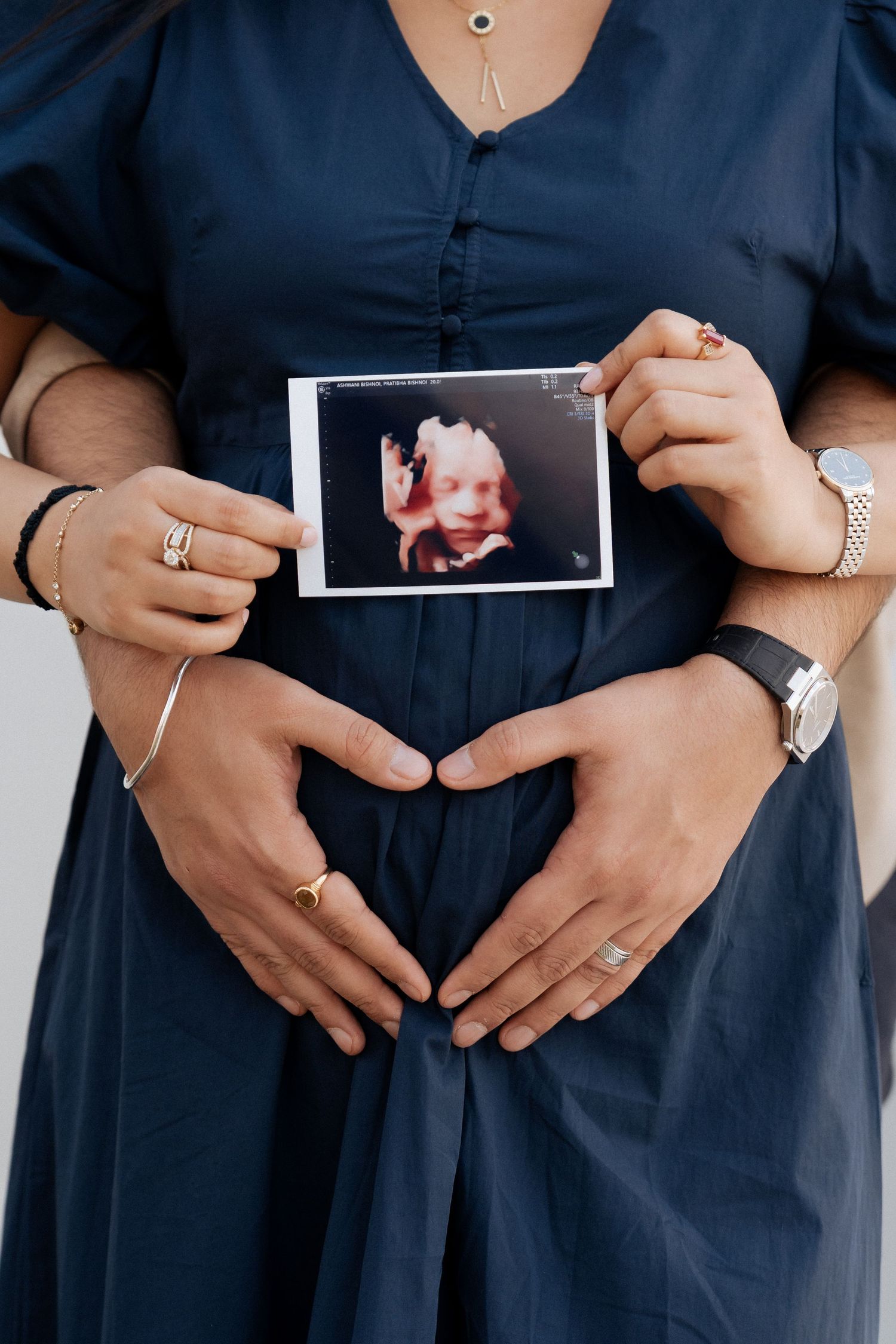 Pregnancy photoshoot in Dubai with couple holding ultrasound scan over baby bump