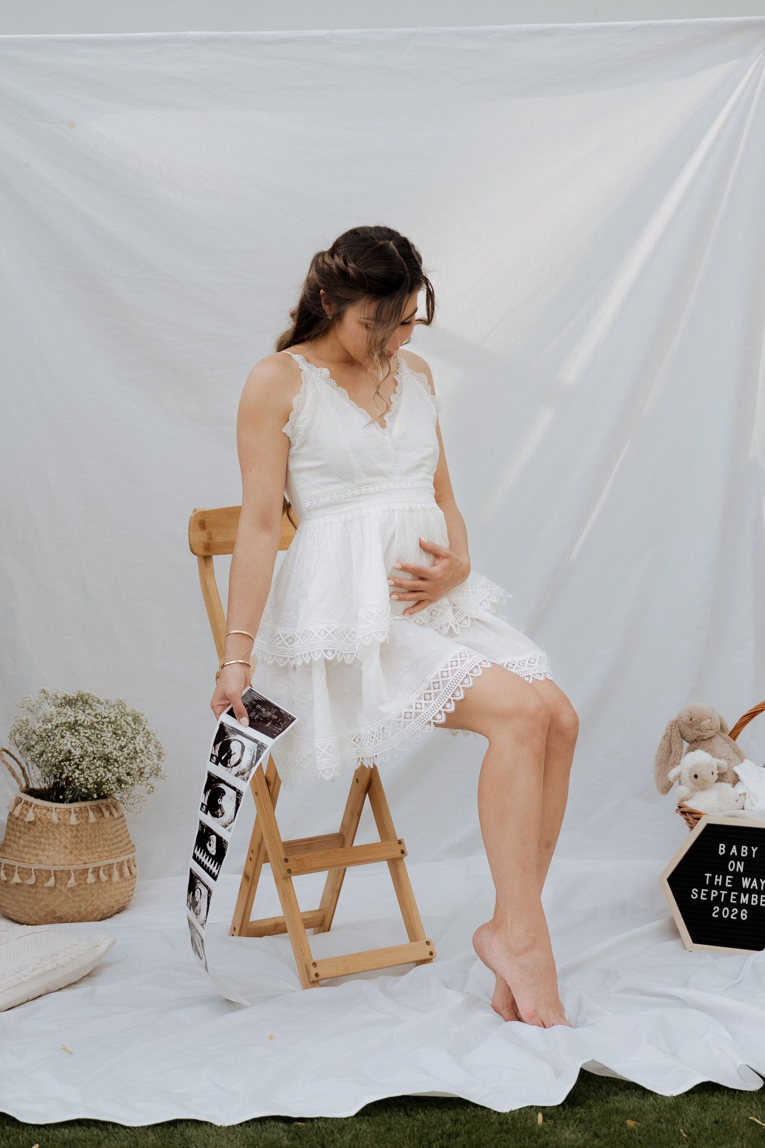 Minimal maternity photoshoot in Dubai with mother-to-be sitting on chair in soft natural light