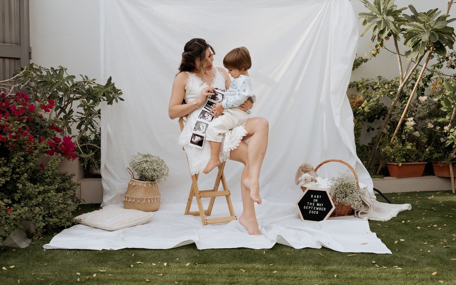 Family maternity photoshoot in Dubai with mother and child sitting in styled outdoor setup