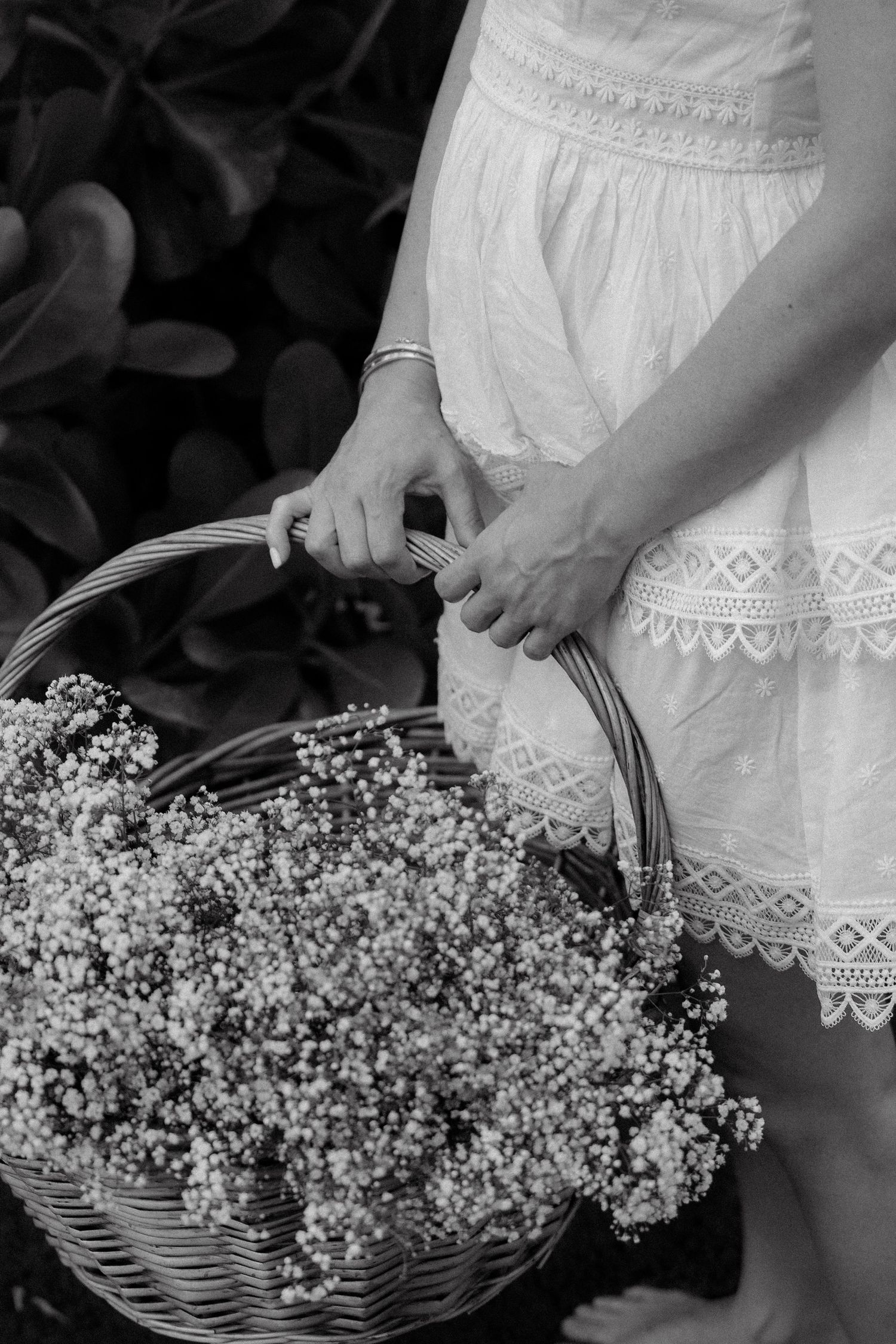 Black and white maternity detail photo holding flowers during pregnancy photoshoot