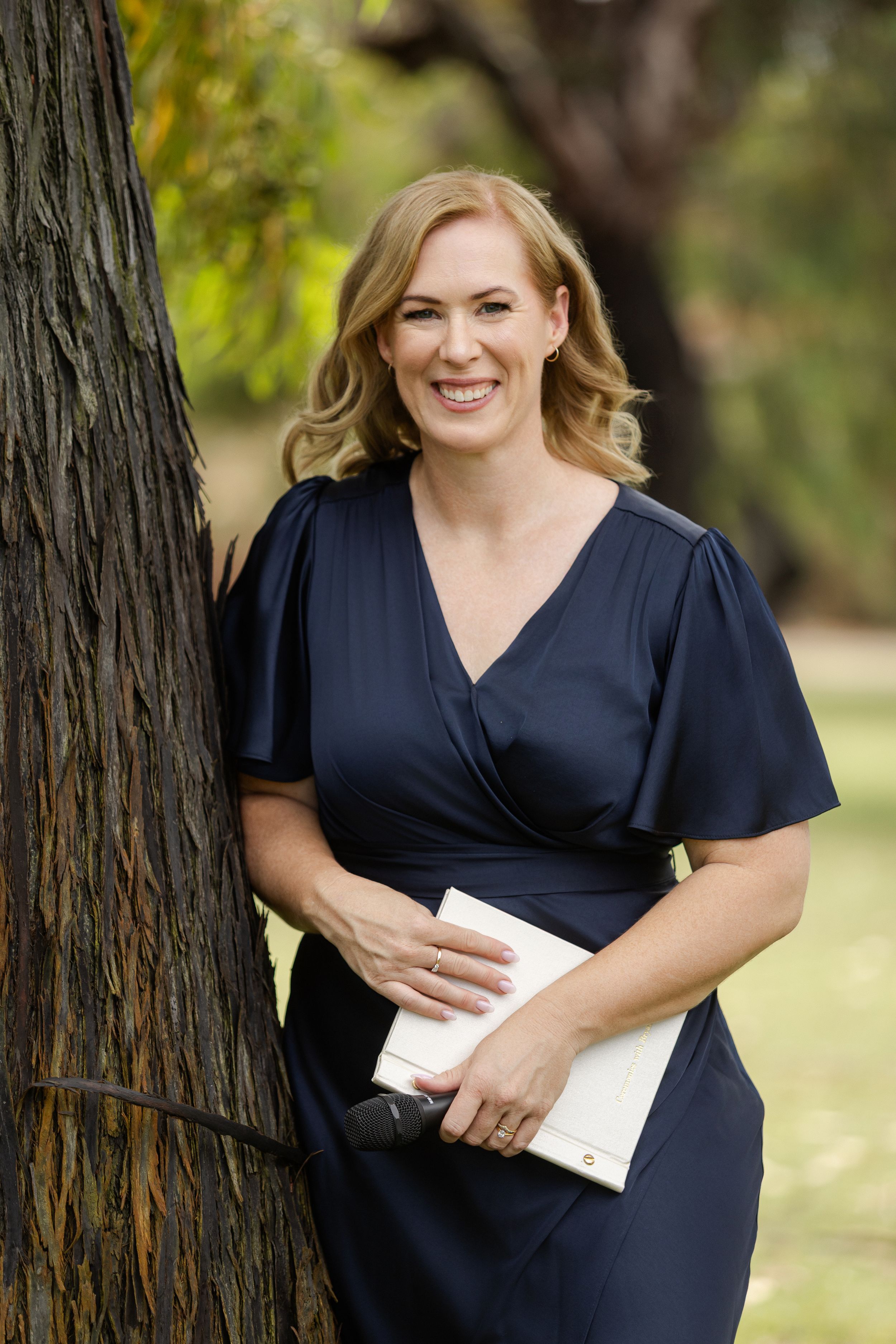 Outdoor portrait session in a natural setting with trees and greenery in the background.