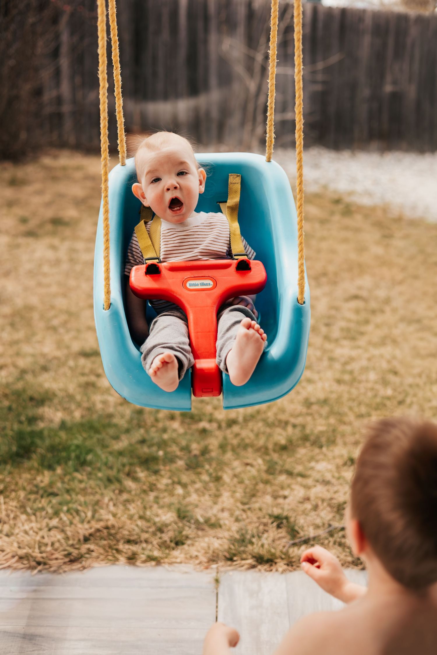 Baby smiling in a blue swing outdoors | Westminster Colorado Photographer