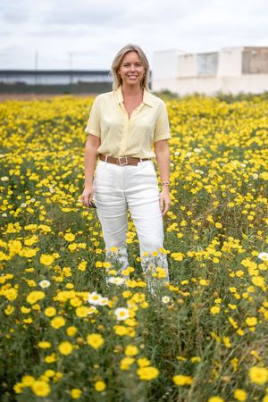 Företagsfoto av Fotograf Jessica Lindqvist - portätt av mäklaren Wessblad Homes i Spanien på ett fält av gula blommor.