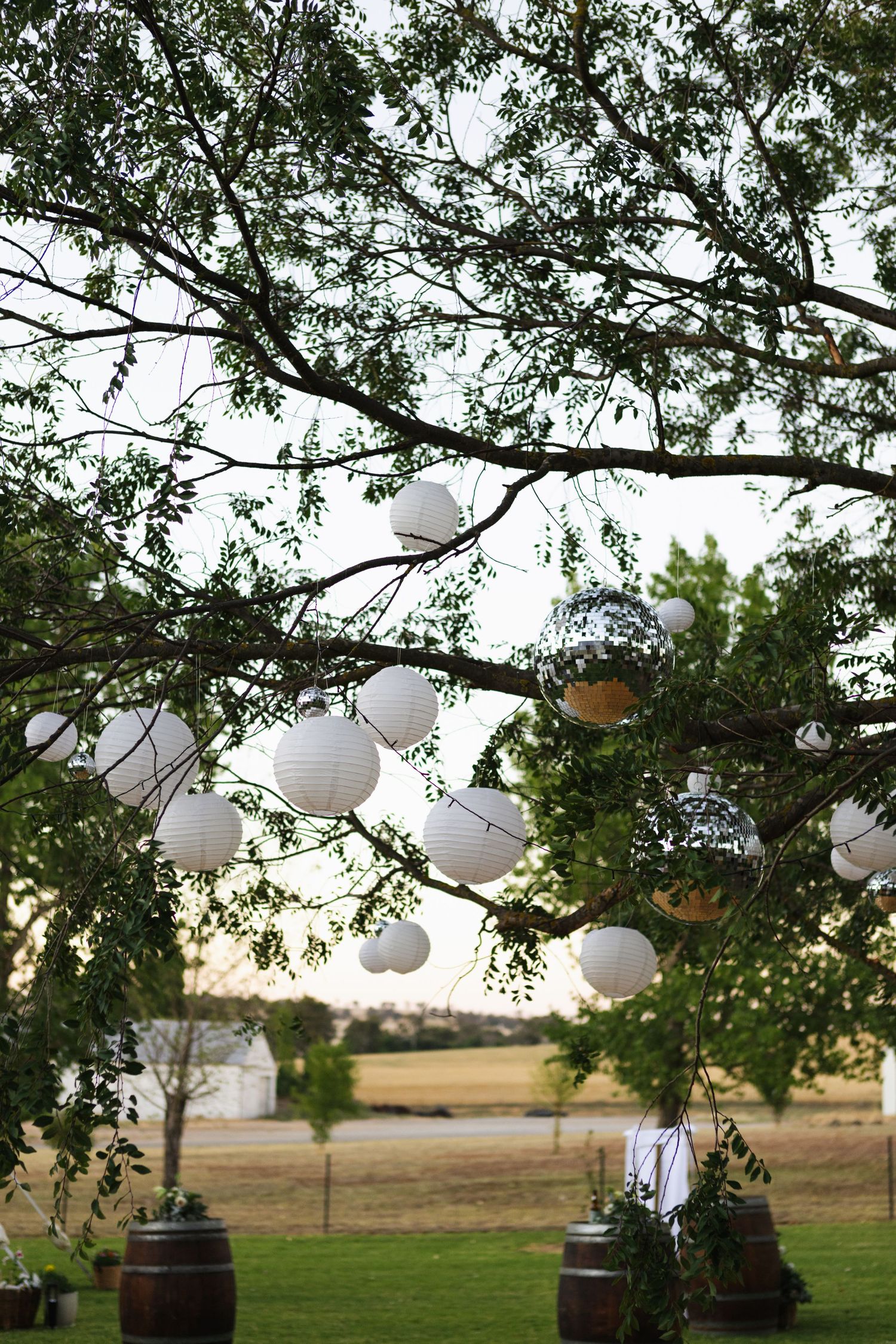 disco balls, lanterns and fairy lights above dance floor at country wedding