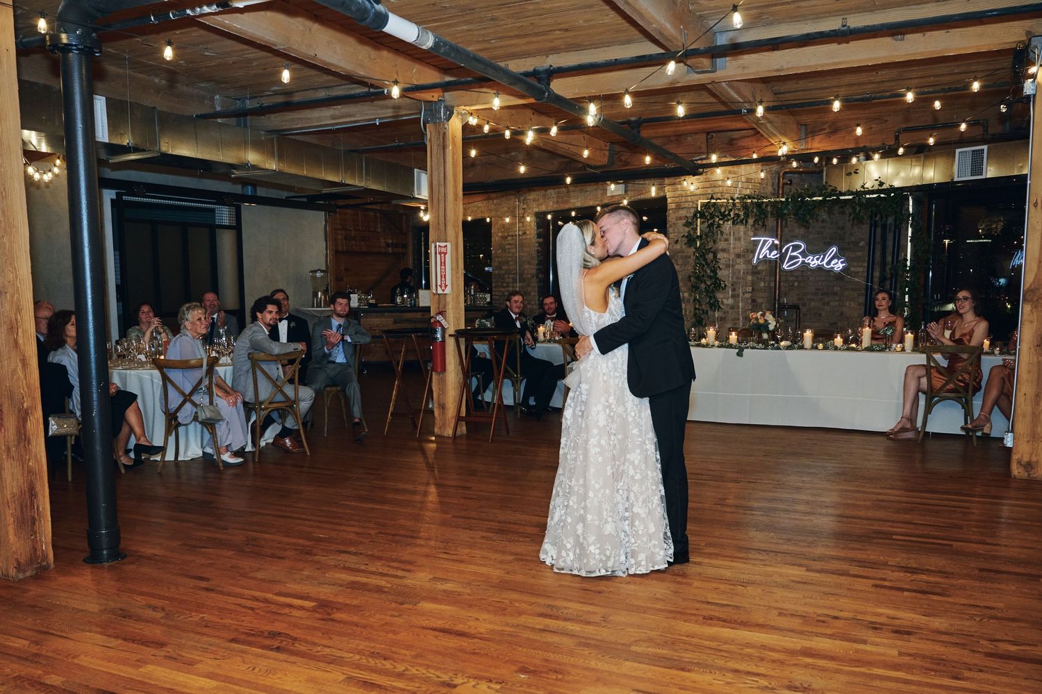 Couples dancing together on a polished wooden dance floor under warm lighting at an elegant indoor venue.